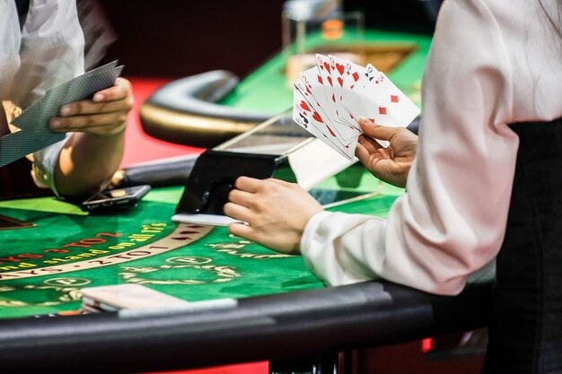 Player arranging Capsa Banting cards at musitoto table with dealer and other players visible